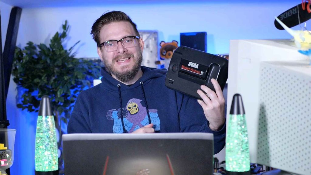 Nostalgia Nerd with a Sega Master System, looking happy about it