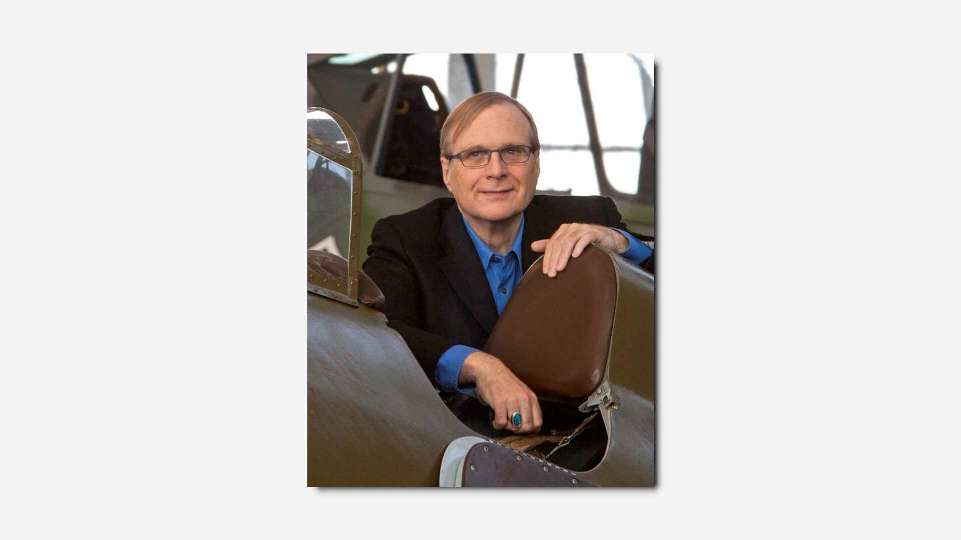 Paul Allen standing next to a bi-plane of some description