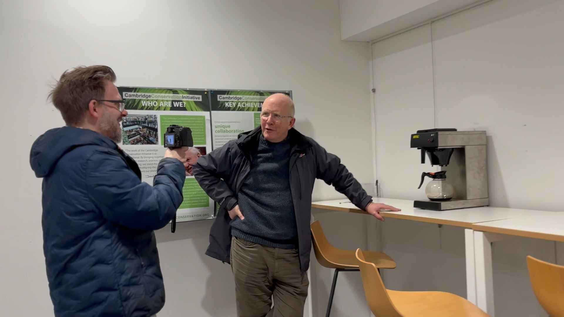 Nostalgia Nerd and Quentin Stafford-Fraser inside the old computer lab, with a coffee machine. Nerd is filming Quentin in front of the pot.